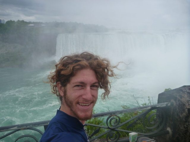 Michael Altfield stands in-front of Niagra Falls in Canada